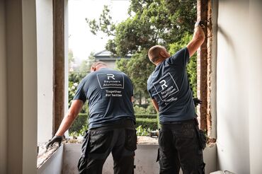 Doi instalatori Reynaers Aluminium demontează ferestre vechi la fața locului.