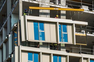 Clădire înaltă bej, cu multe ferestre, în centrul orașului.