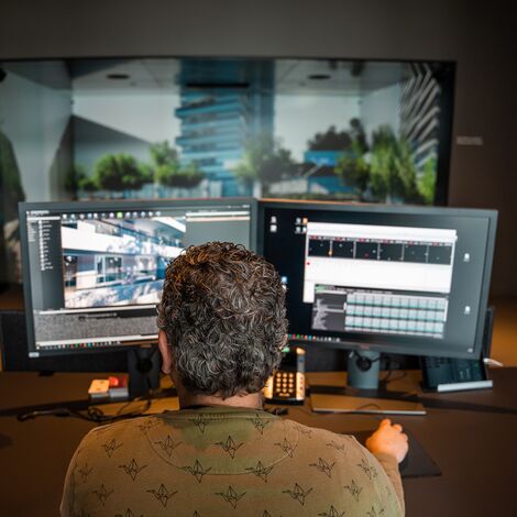 3D expert building models behind two computer screens in the Avalon Virtual Reality Room.