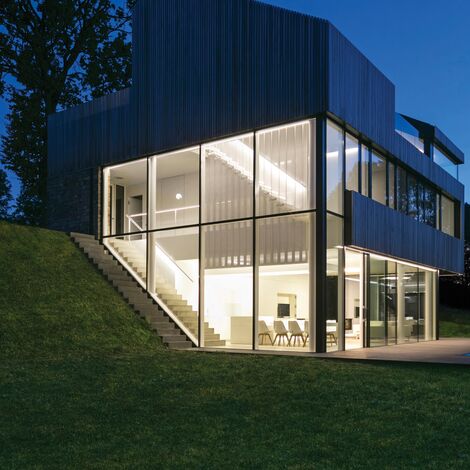 Casă privată bine luminată, cu multe vitralii noaptea.