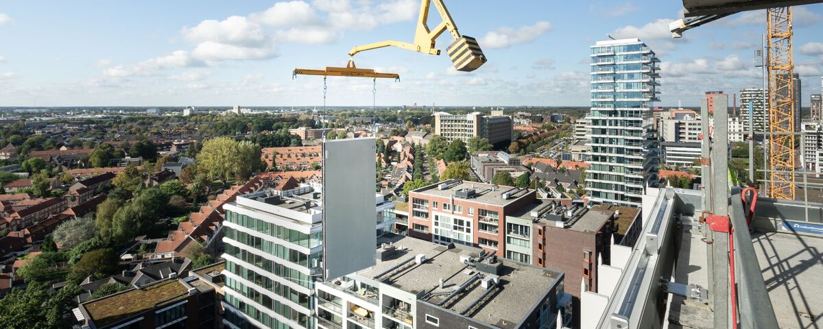 Panou modular de construcție ridicat lângă zgârie-nori.