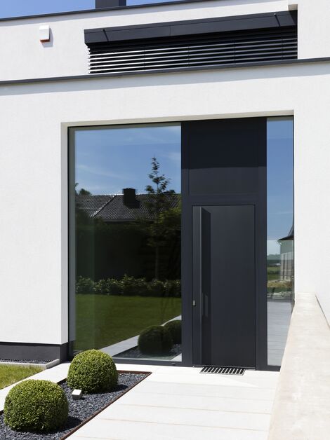 Ușă cu panouri din aluminiu negru într-o casă modernă.