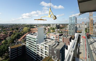 Panou modular de construcție ridicat lângă zgârie-nori.